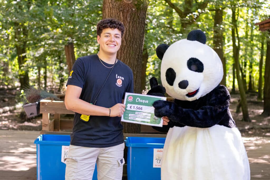 Fun Forest-teamlid overhandigt cheque aan Panda van WWF.