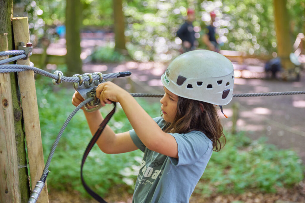 Jongetje met een witte helm oefent in het oefenparcours hoe hij zijn zaza over het zaza plaatje krijgt.